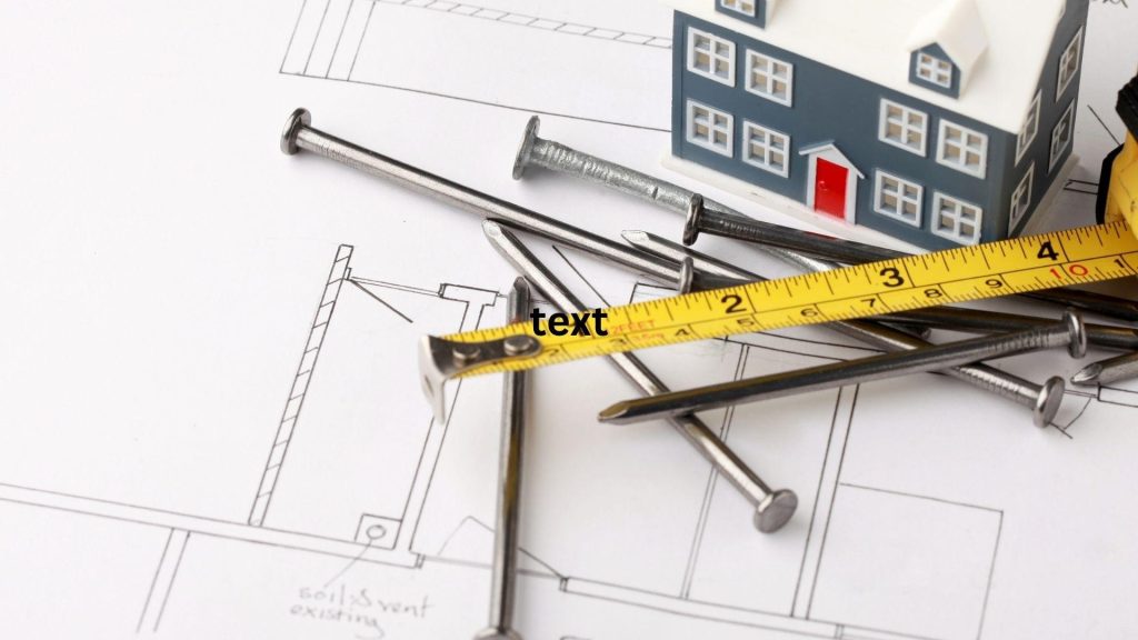 Tape measure, nails and a model house resting on building plans