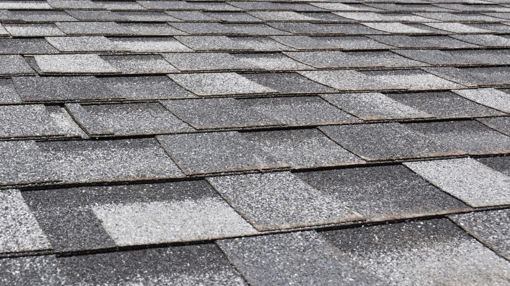 Close-up of an asphalt shingle roof with newer replacement shingles